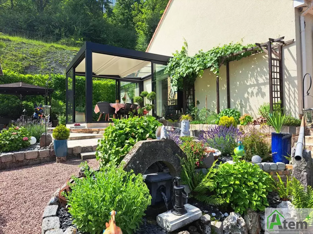 Une véranda aluminium ouverte sur le jardin toute l’année Une véranda aluminium ouverte sur le jardin toute l’année